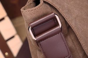 Detail of durable brown canvas fabric and leather strap reinforcement with silver metal buckle
