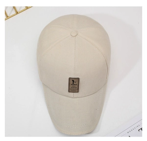 Close-up of beige cotton baseball cap with a brown leather logo patch on a white desk