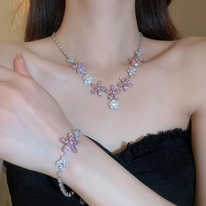 Détail d'un ensemble collier et bracelet avec pendentifs fleurs et zircons roses