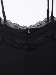 Detalle de encaje negro intrincado y tirantes finos en una camiseta de seda
