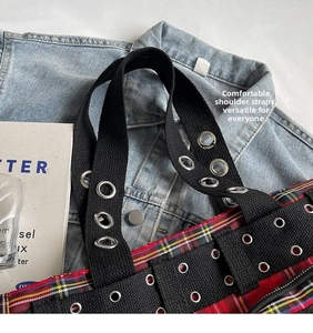 Detail of studded canvas strap and red plaid fabric on this punk style tote bag