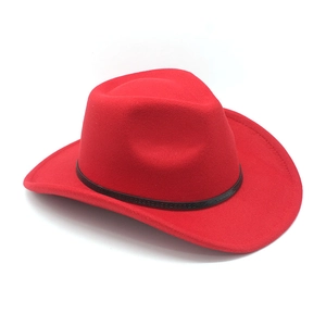 Detail of red cowboy hat with wide rolled brim and black leather decorative band