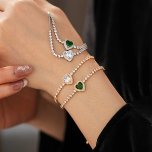 Close-up of heart-shaped zircon bracelets in gold and silver on a model's wrist