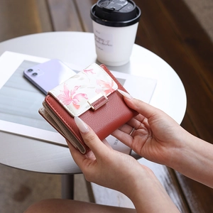 Gros plan d'un petit portefeuille en cuir PU avec motif floral beige et fermoir métallique