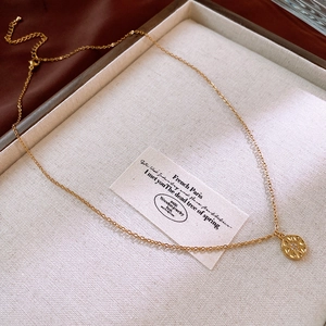 Detail of gold starburst pendant necklace with zircon stone on elegant display tray