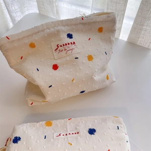 Cute off-white canvas pouch set with colorful dots and a silver zipper for travel