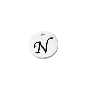 Detailed close-up of a mirror-polished stainless steel round charm with letter N engraving