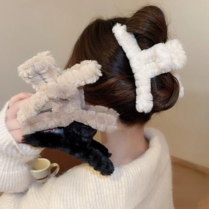 Close-up of plush faux fur shark hair clips in white, beige, and black for women
