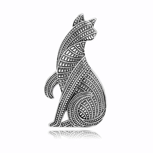 Macro detail of silver vintage cat brooch with intricate geometric textures and patterns
