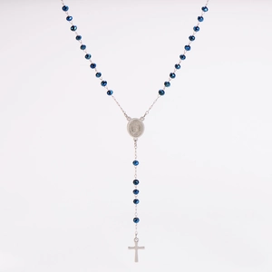 Macro detail of sapphire blue crystal beads and silver rosary cross pendant necklace