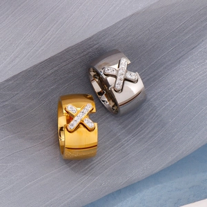 Detailed view of criss-cross X design ring with inset sparkling zircon in gold and silver