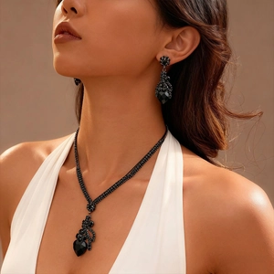Gros plan d'un ensemble collier et boucles d'oreilles avec cœur en cristal noir rétro