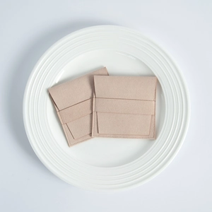 Detail view of pink microfiber suede jewelry pouches on a minimalist white ceramic tray