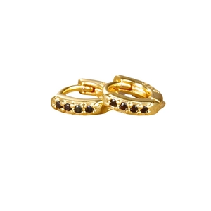Elegant gold hoop earrings with black zircon stones in a minimalist luxury style