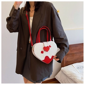 Detailed view of white heart-shaped crossbody bag with red crocodile texture