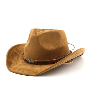 Macro detail of brown suede cowboy hat featuring vintage metal skull ornament