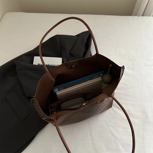 Large brown woven tote bag with PU texture shown in a professional lifestyle flat lay