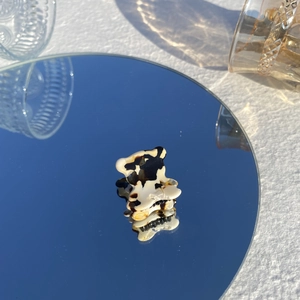 Gros plan d'une mini pince à cheveux motif vache en forme d'ours sur un miroir rond