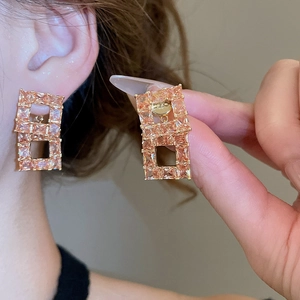 Close-up of model wearing 18K gold plated rectangular hollow earrings with zircon stones