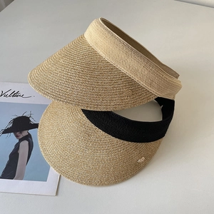 Minimalist straw sun visor hat for women with golden metal detail and stylish woven texture