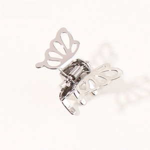 Macro shot of silver vintage metal butterfly hair claw clip with detailed hollow wings