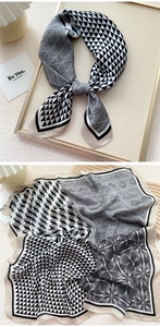 Detailed view of geometric black and white silk scarf with abstract patterns and satin finish