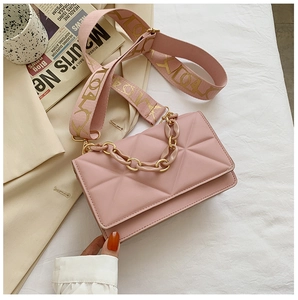 Close-up of pink crossbody bag with geometric quilting and stylish resin chain detail