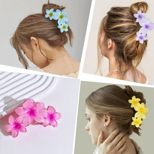Detailed views of matte flower hair claws in multiple colors shown on hair
