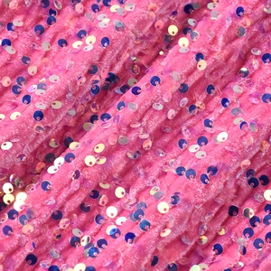 Détail macro du tissu en velours rose avec texture verticale et paillettes pour pantalon habillé
