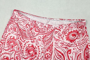 Détail d'imprimé géométrique rouge et crème sur legging montrant les coutures précises