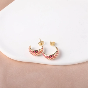 Detail of gold-plated hoop earrings with vibrant pink enamel stripes and butterfly backs
