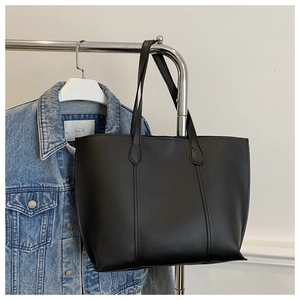 Détail du grand sac cabas en cuir mat noir avec surpiqûres verticales sur le devant