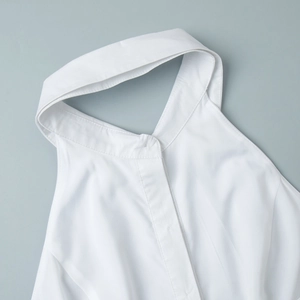 Détail d'une robe dos nu blanche avec col chemise et épaules dénudées élégantes