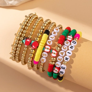Detail of beaded bracelets with heart and apple charms stacked on a display stand