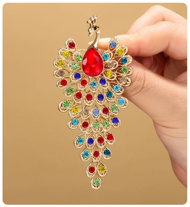 Detailed view of peacock brooch with colorful rhinestones and a large red center stone