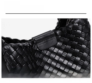 Detail showing the intricate hand-woven leather texture and magnetic buckle of the black bag