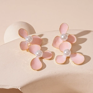 Pink floral drop earrings with white pearls and gold edges on elegant display stand