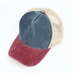 Detail of washed denim baseball cap with distressed brim and breathable mesh back