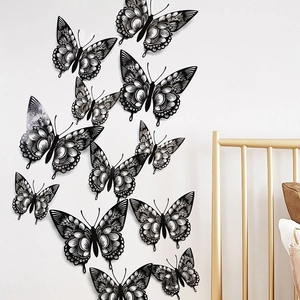 Detailed close-up of various sized black hollow-out butterfly wall stickers on a white wall