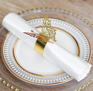 Detailed close-up of golden butterfly laser-cut napkin ring on elegant white tableware