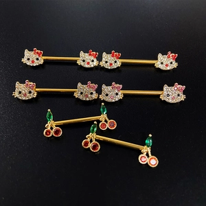 Detail of Hello Kitty and cherry nipple rings with sparkling crystals on gold metal