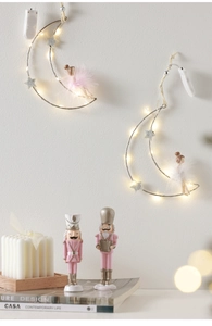 Macro detail of moon-shaped LED ornament with warm lights and delicate feather doll