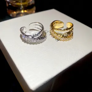 Elegant gold and silver triple-layered crisscross open rings with sparkling cubic zirconia
