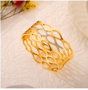 Detailed shot of golden hollowed-out titanium steel bracelet with sparkling pavé crystals