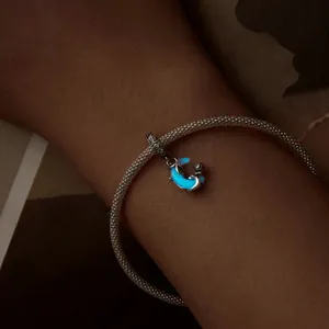 Luminous S925 sterling silver moon cat charm with blue glow effect on silver bracelet