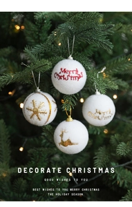Close-up of white flocked Christmas ball with gold reindeer embroidery on tree