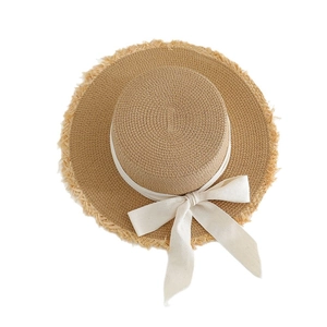 Flat top straw boater hat with frayed edges and white ribbon bow for beach vacation