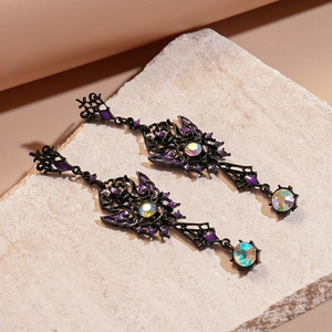 Macro detail of gothic black butterfly earrings with purple enamel on stone