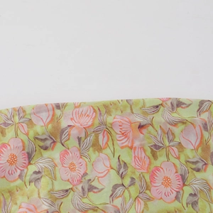 Gros plan d'imprimé floral rose et gris sur tissu mousseline vert clair