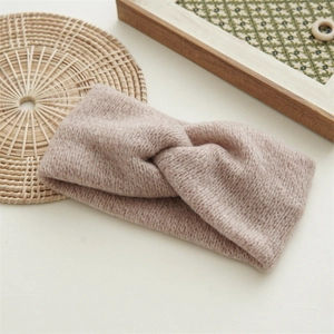 Close-up of thick knitted twist knot headband in soft light brown wool texture